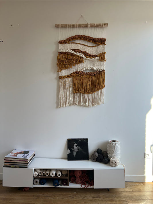 Woven tapestry displayed above a console table with decorative accents