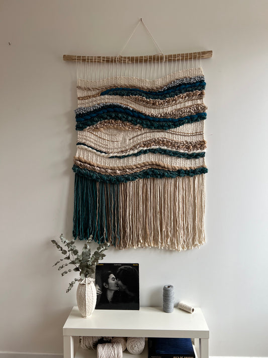 Handwoven wool wall tapestry above nightstand in cozy bedroom
