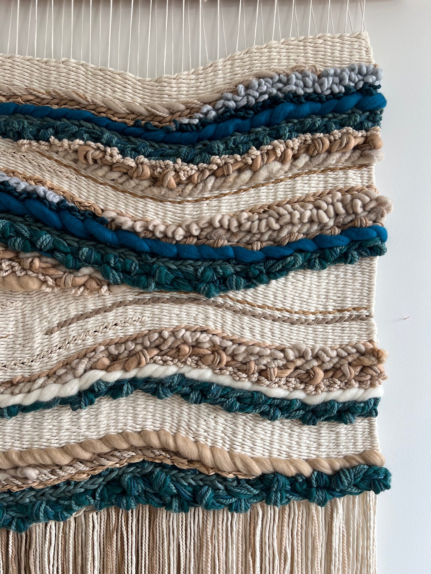 Detailed view of textured weaving on handwoven fiber art wall hanging