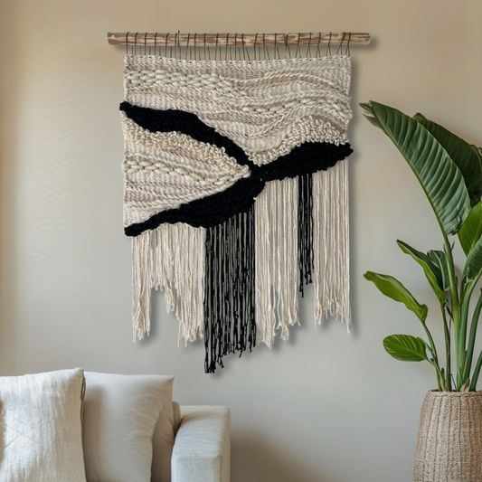 Boho-style handwoven wall art in neutral and dark tones featured as decor in a modern living room