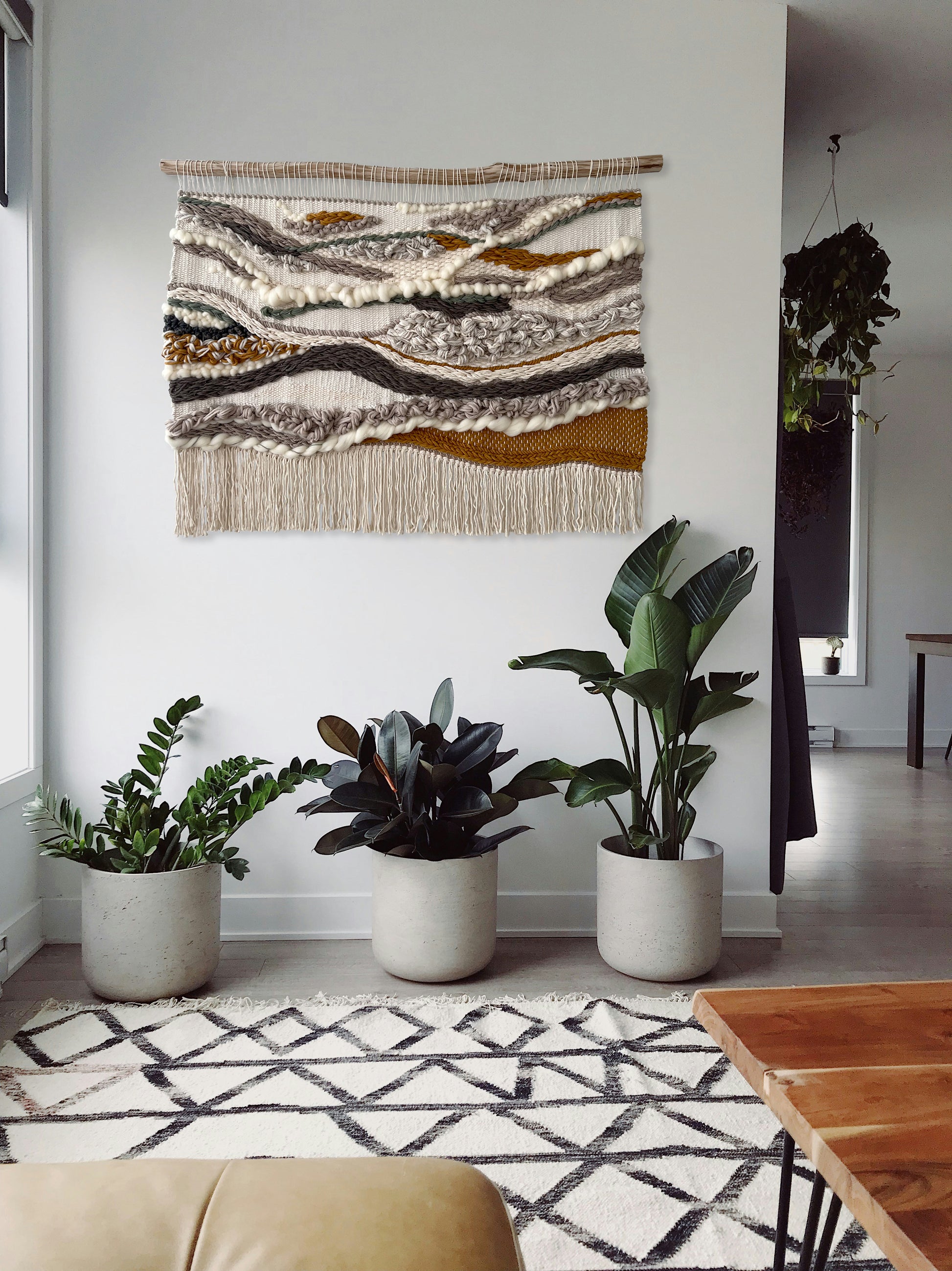 Handwoven 3D wall hanging styled above indoor plants in natural home decor