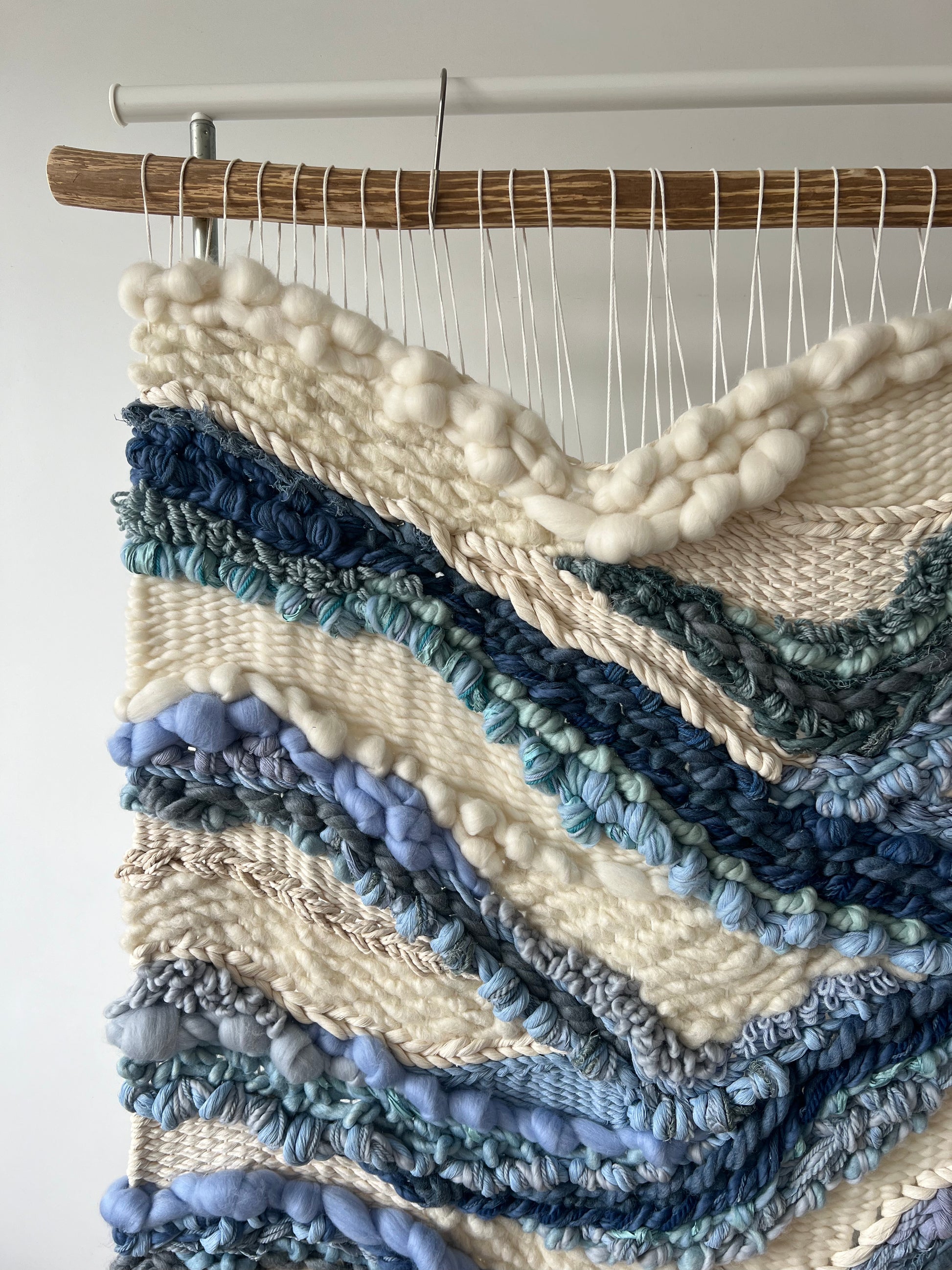Vertical wall hanging in cream and blue, abstract river style pattern
