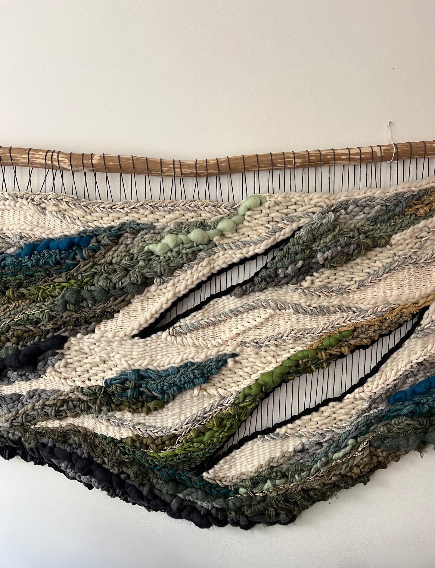 Detail of handwoven wall hanging highlighting organic uneven edges and earthy color transitions