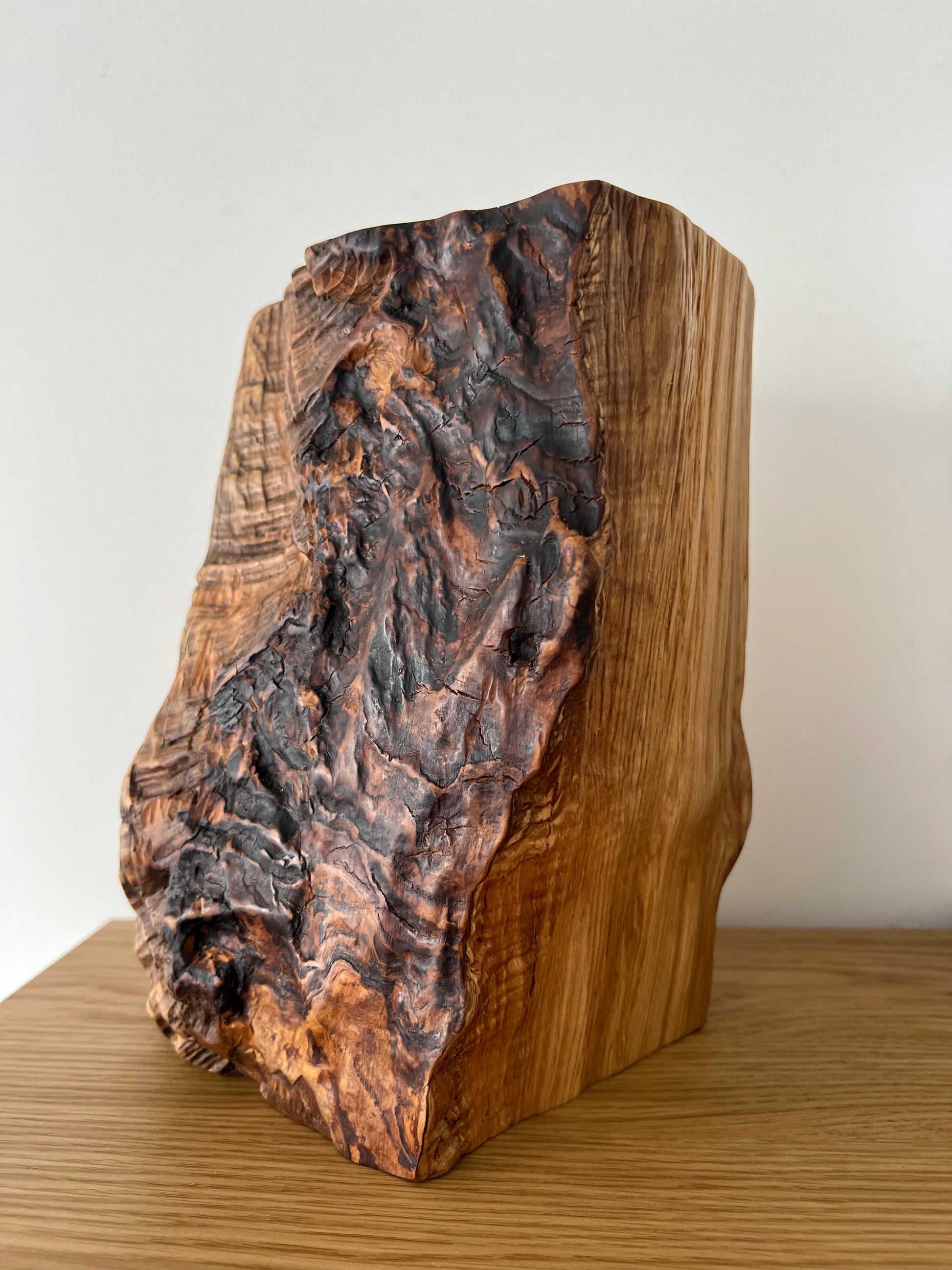 Ash wood lamp base photographed from the side, highlighting natural variations in color and texture.