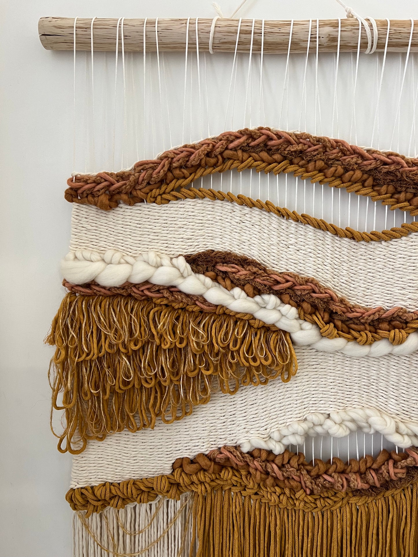 Macro shot of thick woven cream wool and mustard tones in boho tapestry