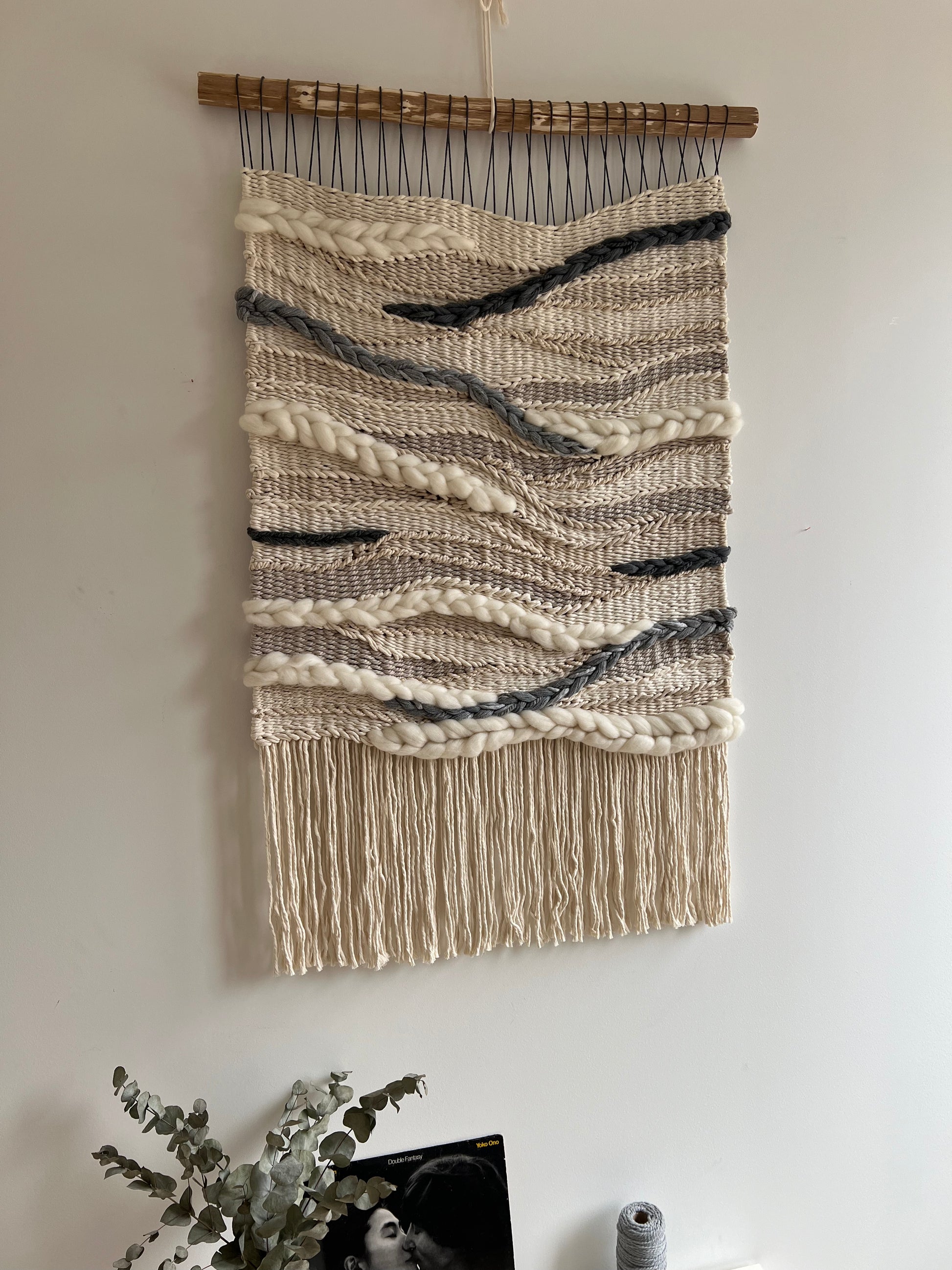 Fiber wall art photographed from the side, highlighting dimensional weaving