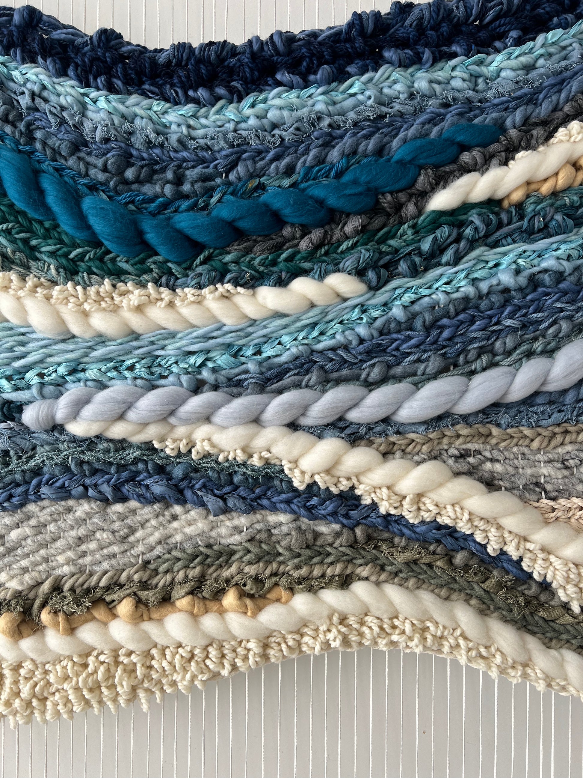 Close-up of thick woven texture in wool tapestry, deep blue and light tones